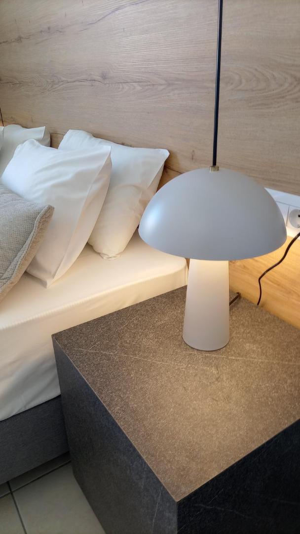 Tuvplāns ar naktsgaldiņu, modernu lampu un gultas piederumiem Pylea Beach Hotel numurā Rodā