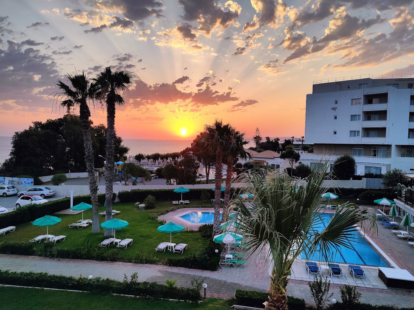 Pylea Beach Hotel skats no augšas uz baseinu zonu un dārzu saulrieta laikā Rodas salā, Grieķijā