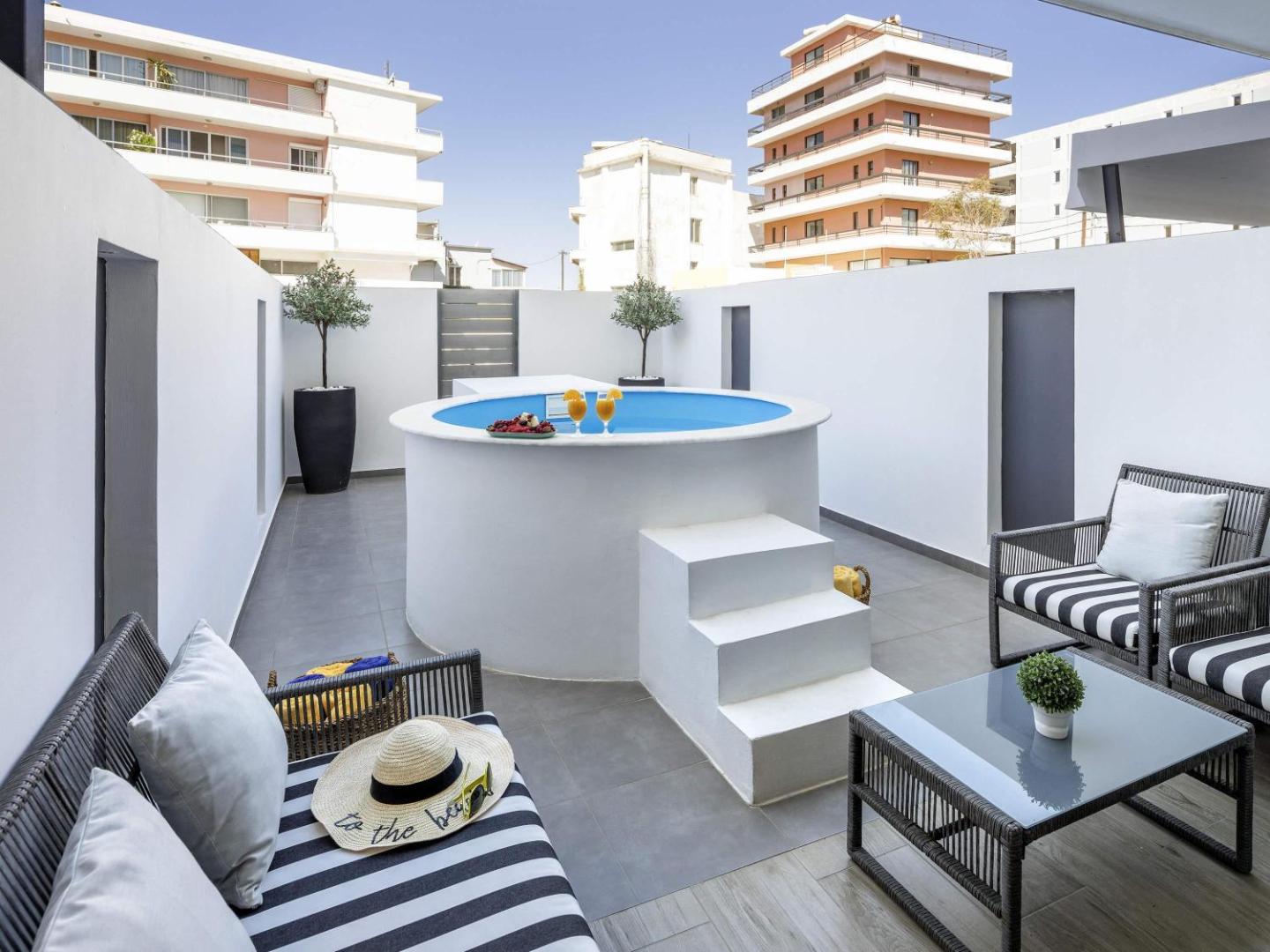 Mercure Rhodes Alexia Hotel & Spa privātā terase ar nelielu baseinu, atpūtas mēbelēm un skatu uz Rodas pilsētas ēkām