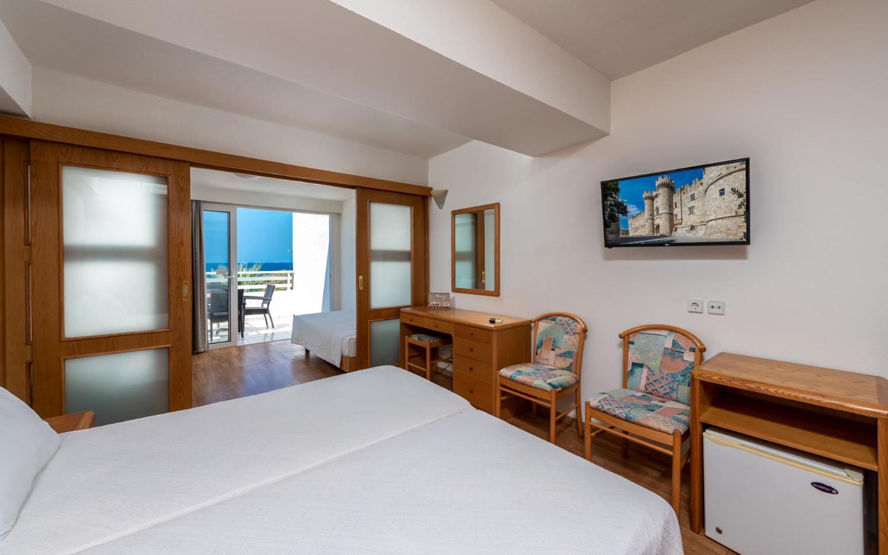 Sirene Beach Hotel ģimenes numurs ar bīdāmām durvīm, koka apdari un skatu uz jūru Rodas salā, Grieķijā