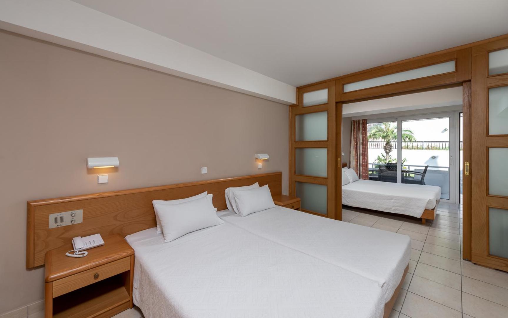 Sirene Beach Hotel plašs ģimenes numurs ar divām guļamistabām, ko atdala bīdāmas koka durvis ar matētu stiklu