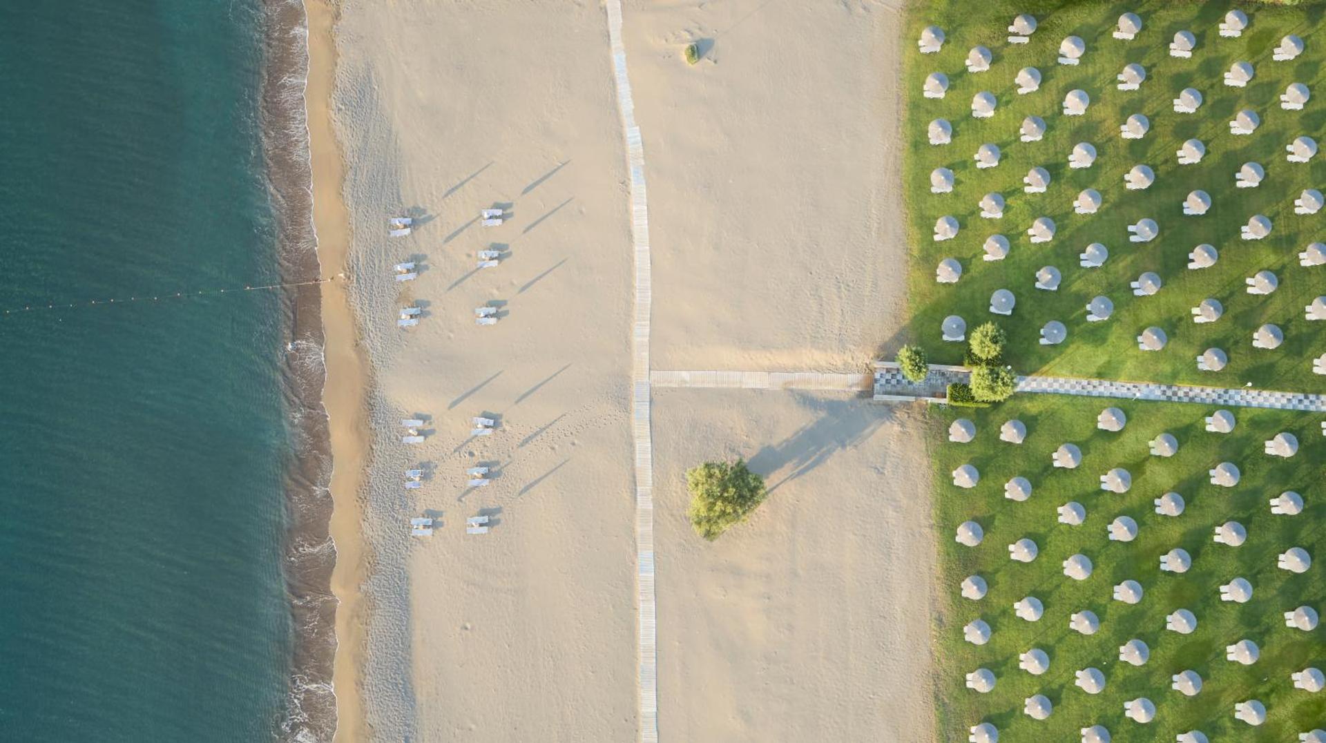 Aerofoto skats uz Apollo Beach viesnīcas pludmali un zālāju ar saulessargiem Faliraki kūrortā Rodas salā
