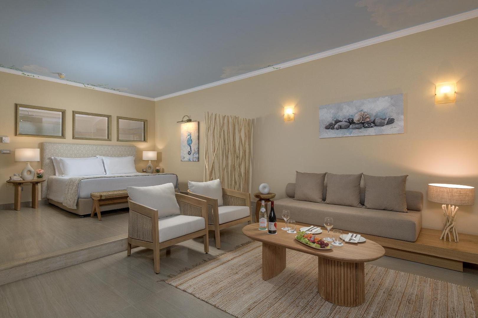 Atrium Prestige Thalasso Spa Resort & Villas plašs luksusa numurs ar atpūtas zonu, dīvānu un mājīgu interjeru siltos toņos