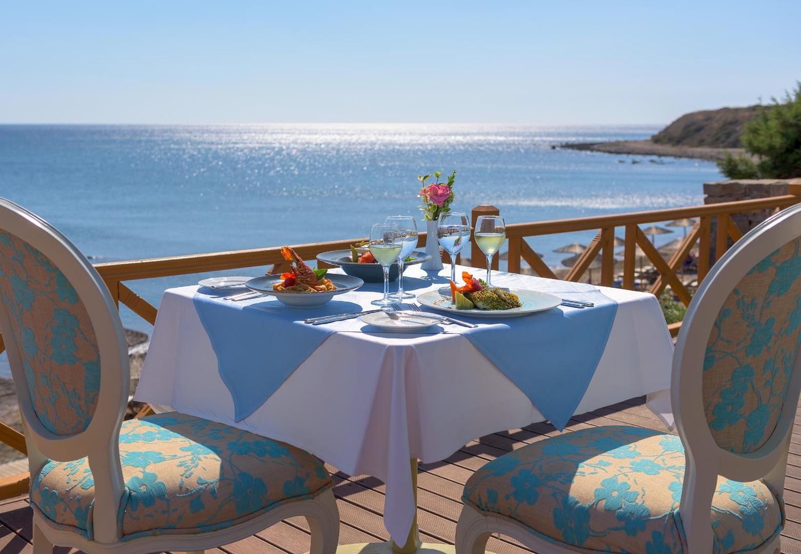 Atrium Prestige Thalasso Spa Resort & Villas ēdienkartes restorāns uz terases ar skatu uz jūru — klāts galds diviem