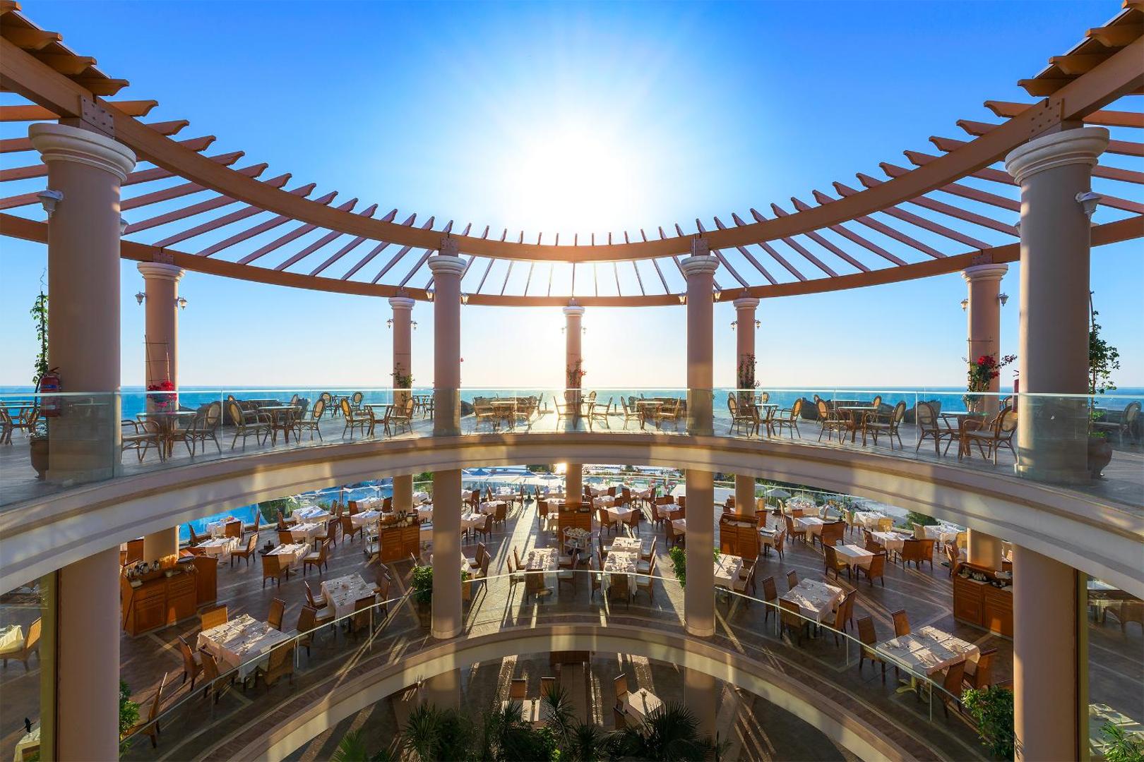 Atrium Prestige Thalasso Spa Resort & Villas daudzlīmeņu restorāns ar panorāmas skatu uz jūru un klasisku arhitektūru