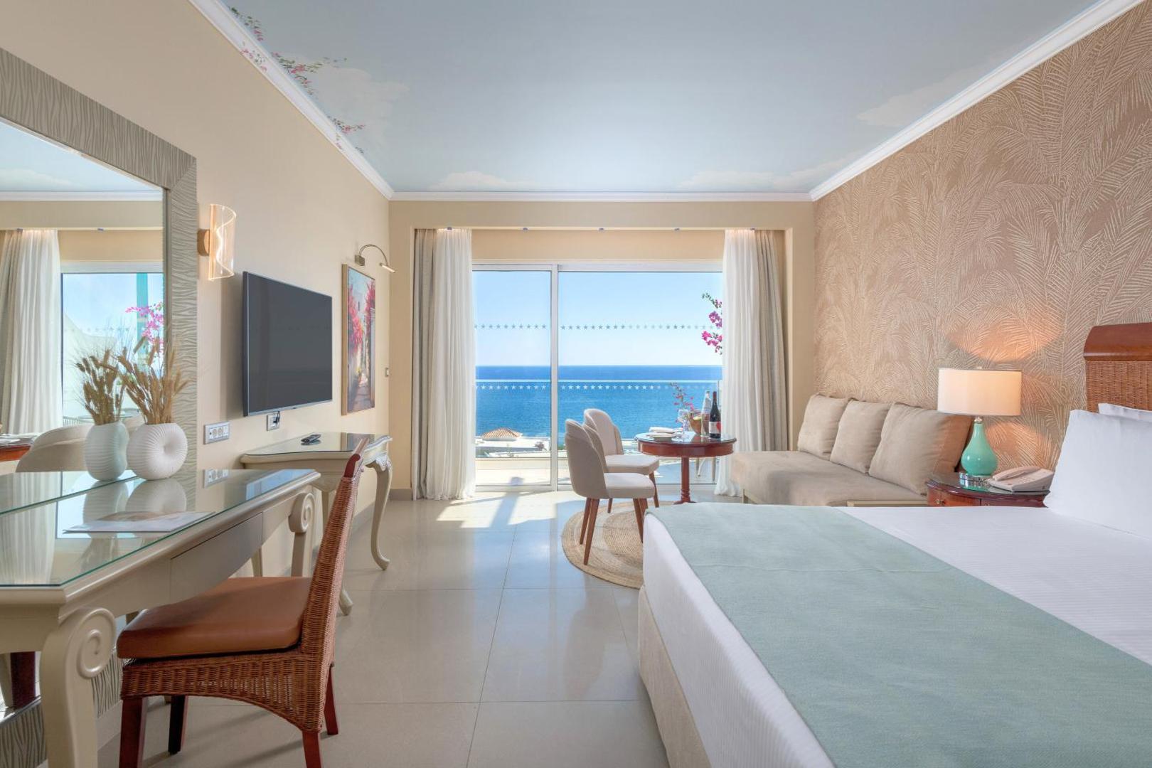 Elegants Atrium Prestige Thalasso Spa Resort & Villas viesnīcas numurs ar panorāmas logiem, atpūtas zonu un skatu uz jūru