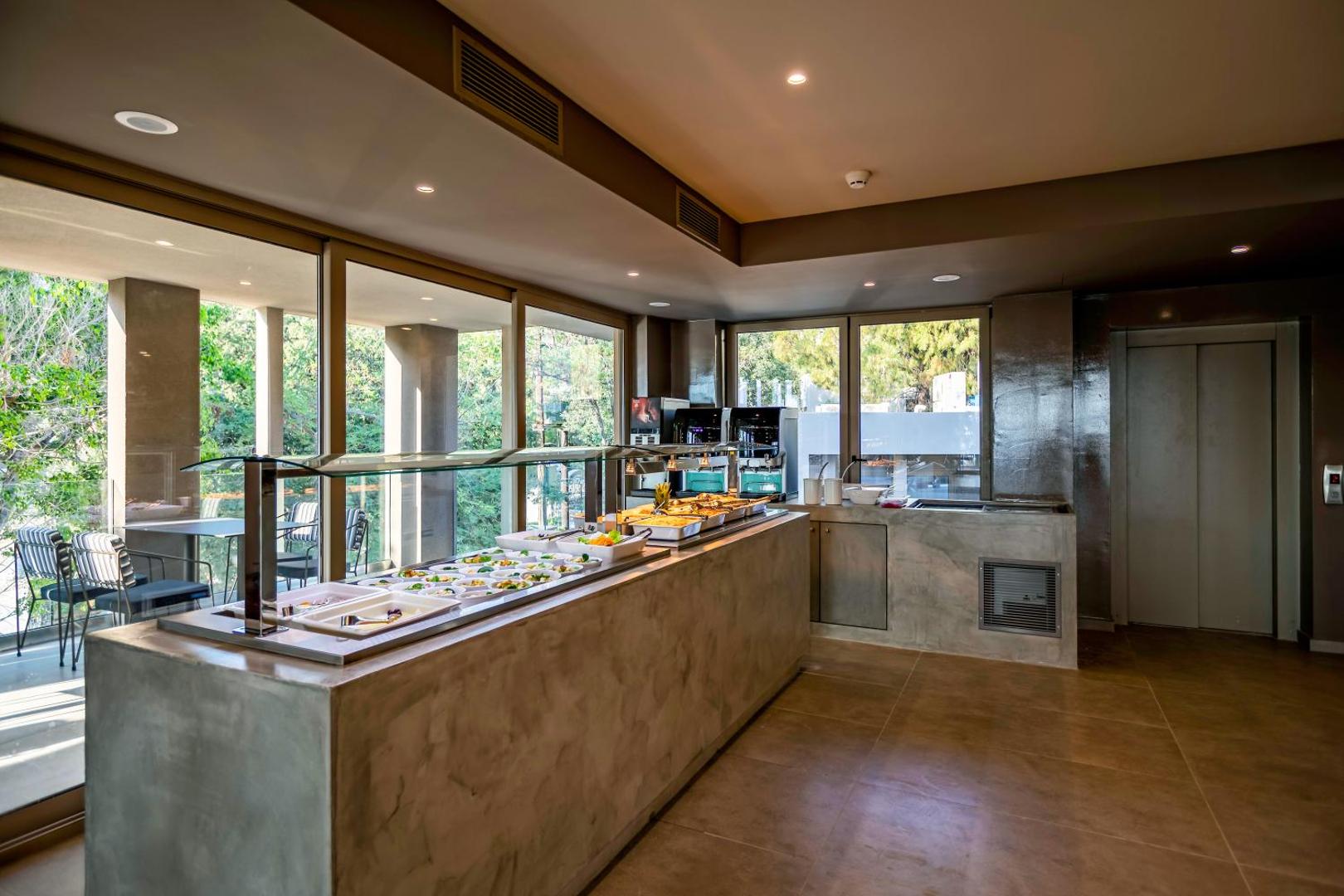 White Olive Premium Lindos bufetes tipa restorāna pašapkalpošanās zona ar uzkodām un siltajiem ēdieniem modernā interjerā