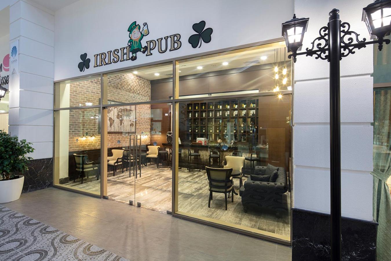 Dosinia Luxury Resort iekštelpu Irish Pub bārs ar koka apdari, ādas dīvāniem un plašu dzērienu izvēli