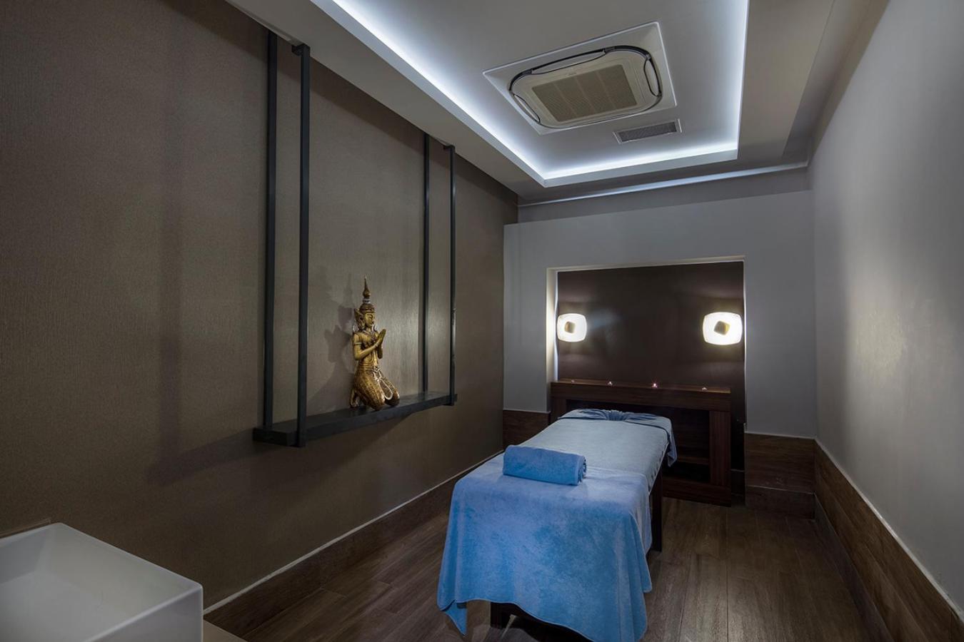 Dosinia Luxury Resort spa masāžas kabinets ar mierīgu apgaismojumu, masāžas galdu un austrumnieciskiem dekoru elementiem