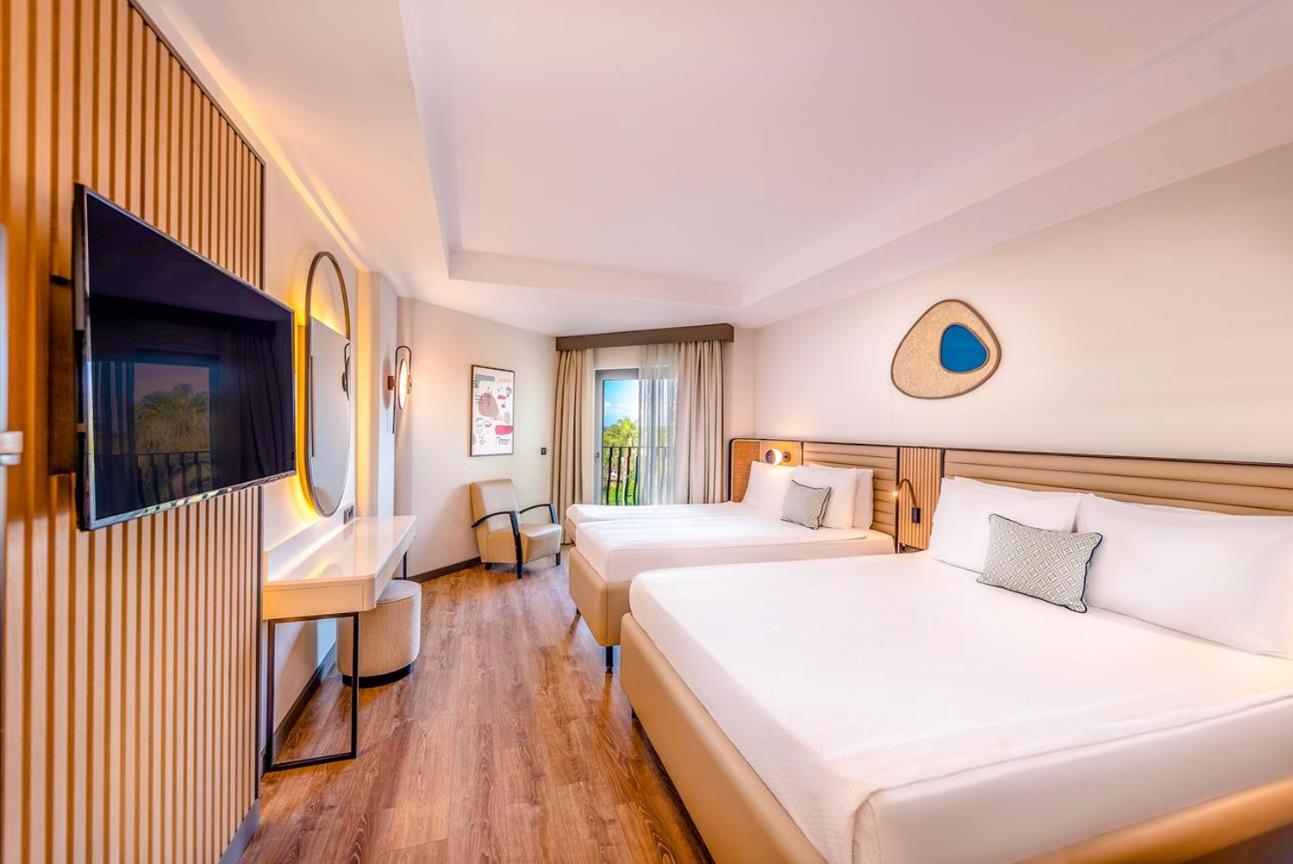 Belek Beach Resort gaišs ģimenes numurs ar divām gultām, koka grīdu un modernu sienas dekoru Turcijas piekrastē