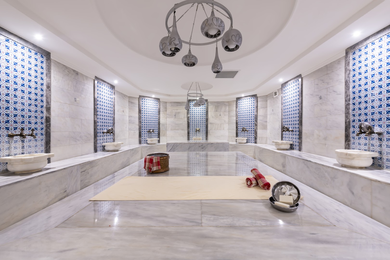 Belek Beach Resort viesnīcas tradicionālais turku hammam ar marmora apdari, dekoratīvām flīzēm un mazgāšanās traukiem relaksējošai spa atpūtai Belekā.