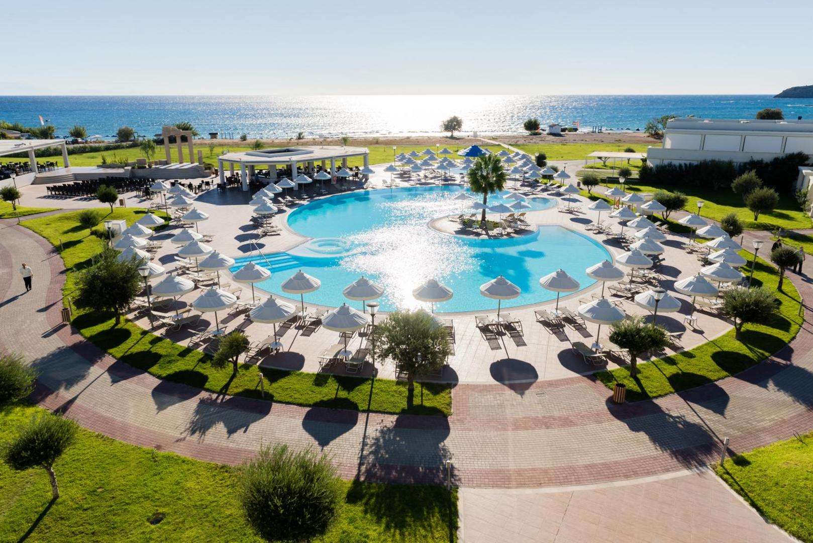 Apollo Blue Hotel plašais āra baseins Faliraki piekrastē Rodas salā — skats no augšas uz sauļošanās zonu un jūru fonā