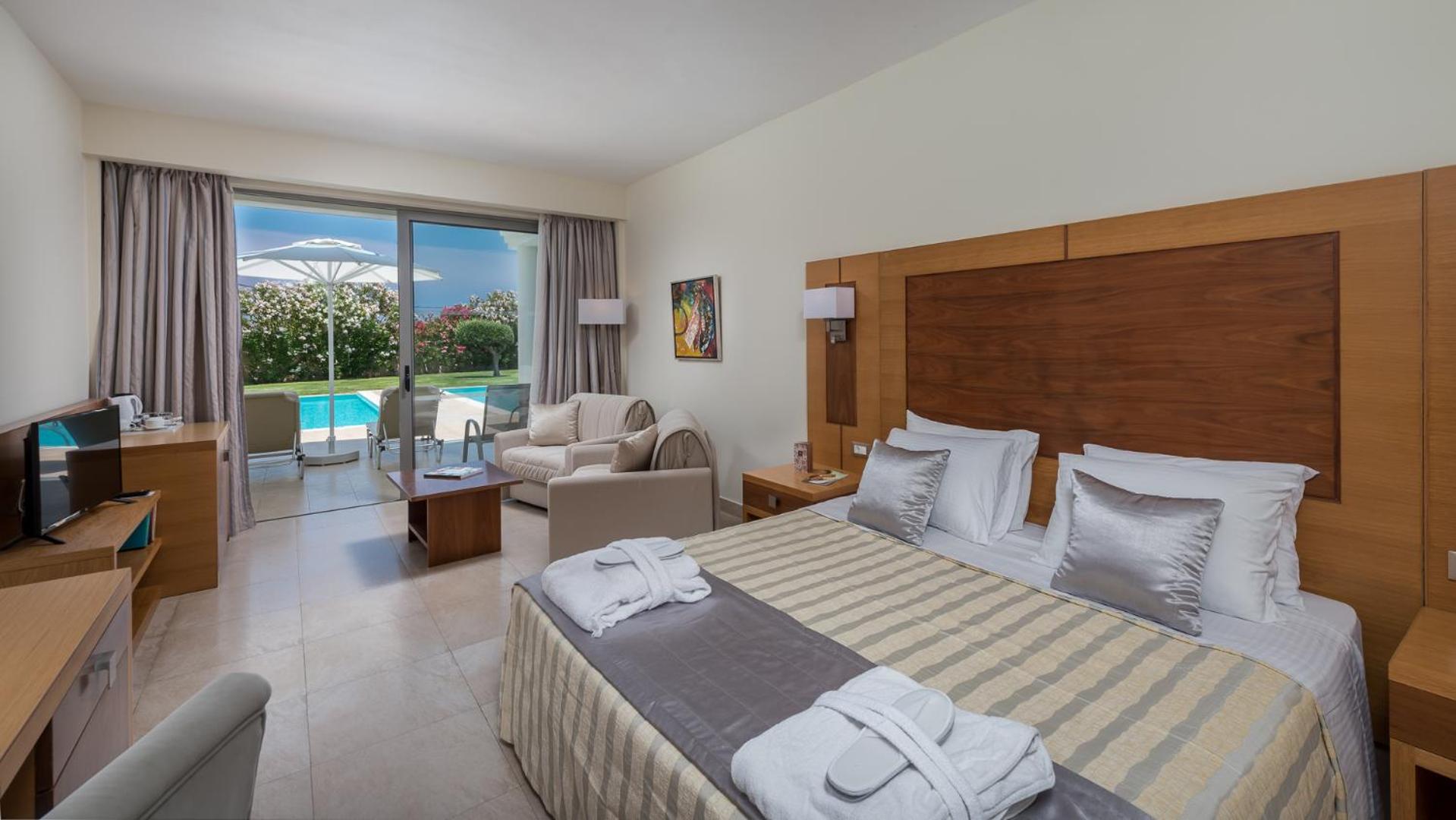 Apollo Blue Hotel numurs ar tiešu piekļuvi baseinam Rodā — gaišs interjers, divguļamā gulta un terase ar skatu uz dārzu