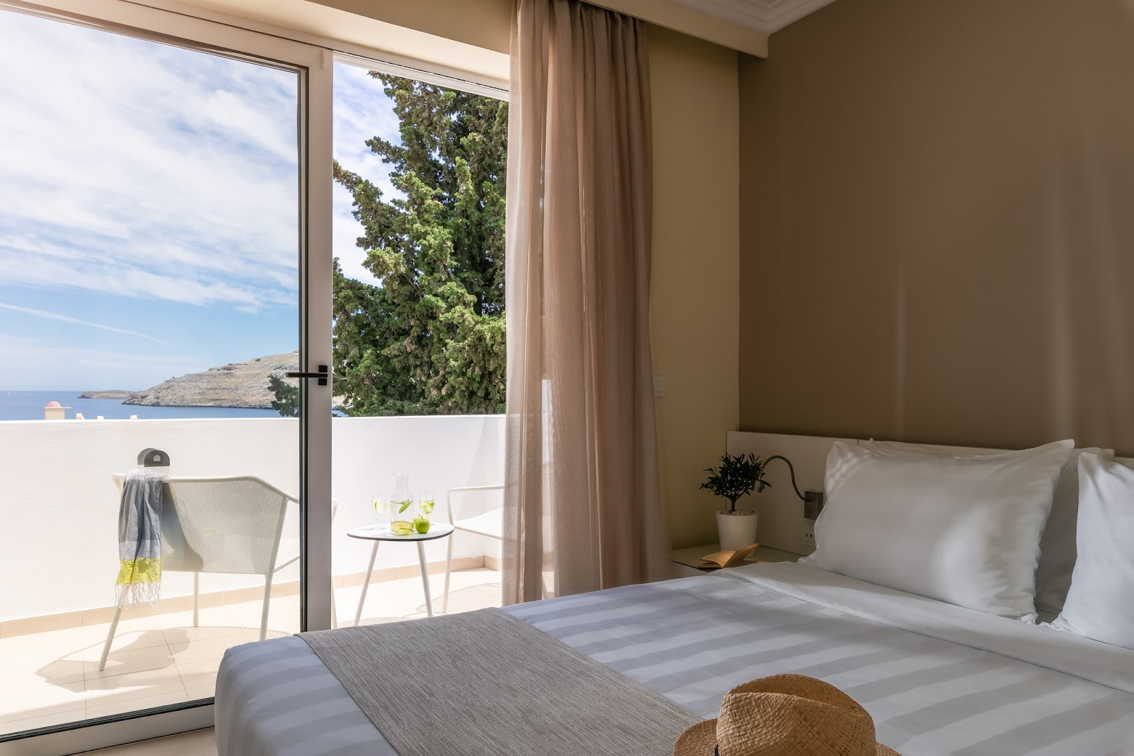 Lindos Village Resort & Spa gaišs numurs ar balkonu, no kura paveras skats uz jūru un Rodas salas piekrasti