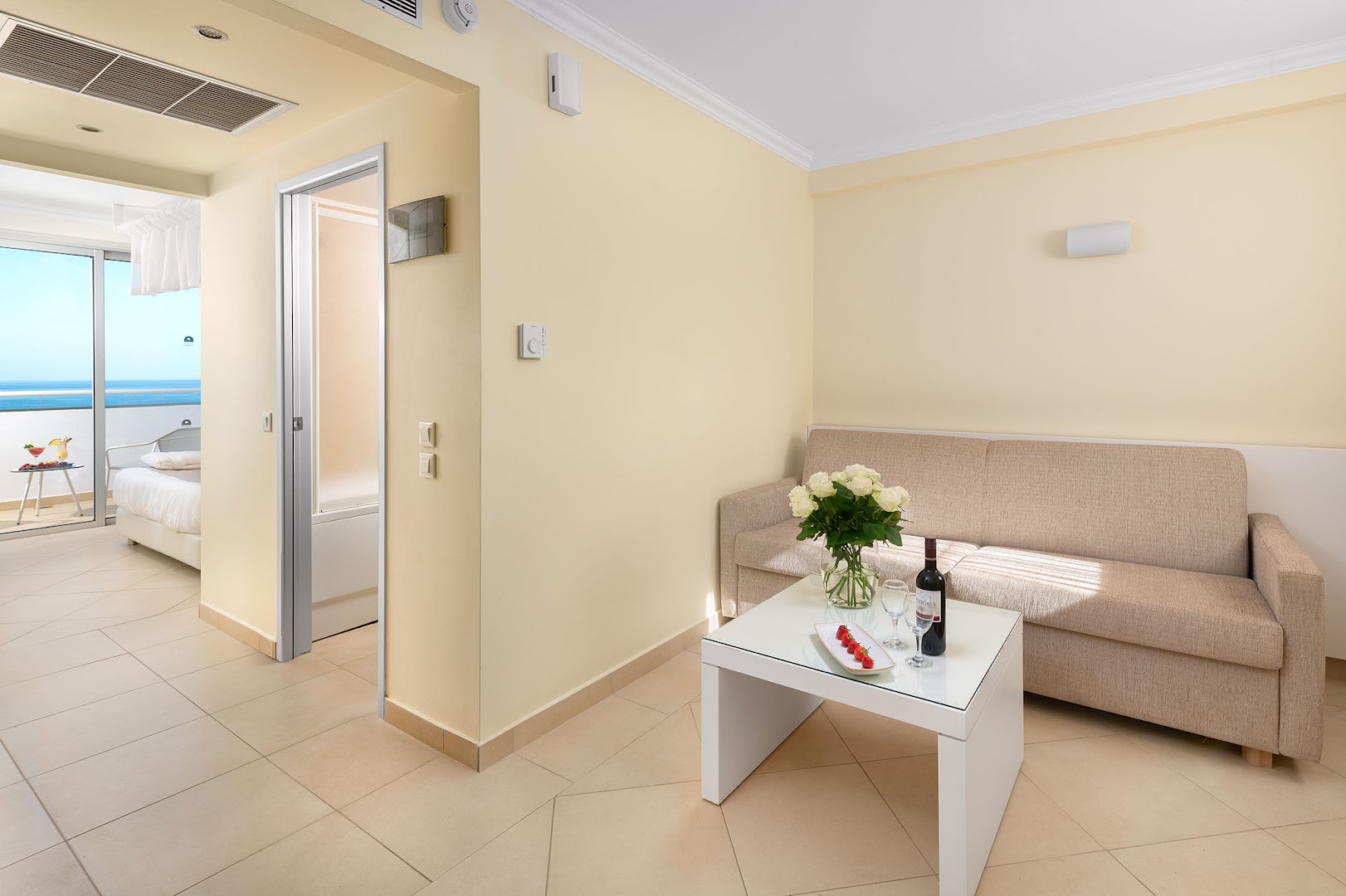 Lindos Village Resort & Spa plašs viesnīcas numurs ar atpūtas zonu, dīvānu un skatu uz balkonu Rodas salā