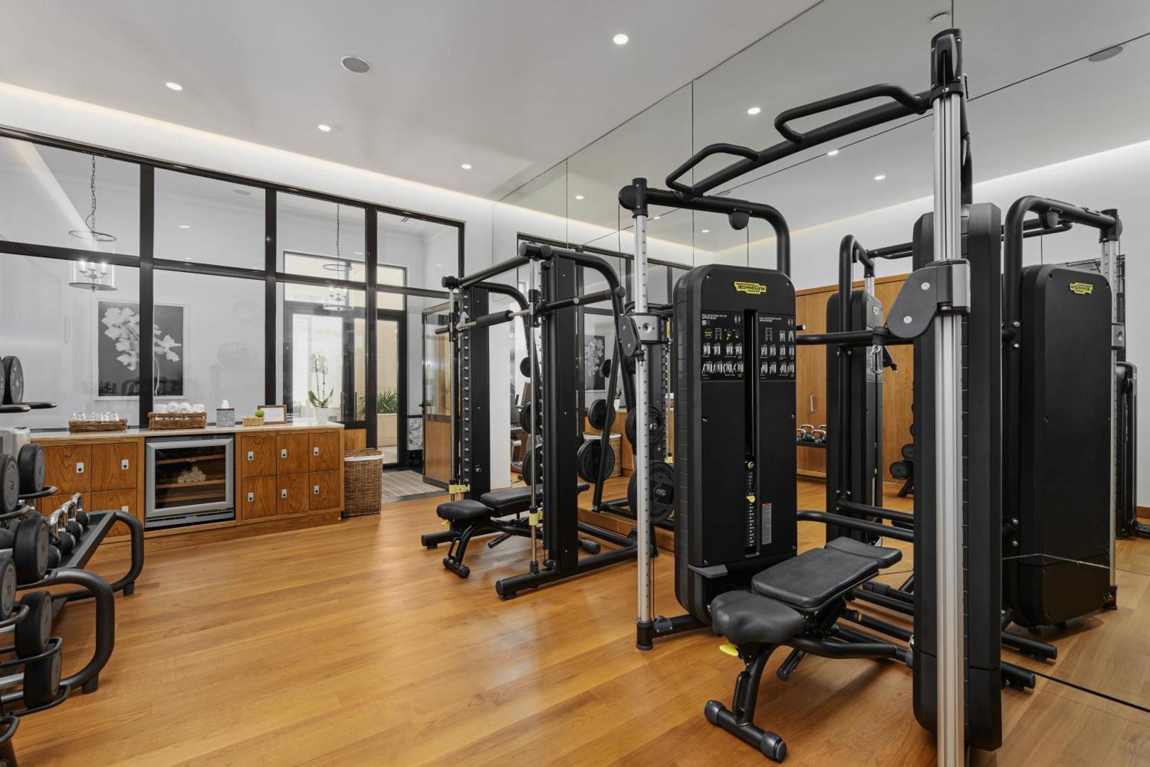 Mūsdienīgs Regent Porto Montenegro fitness centrs ar Technogym aprīkojumu, spoguļsienām un koka grīdu — plaša trenažieru zāle