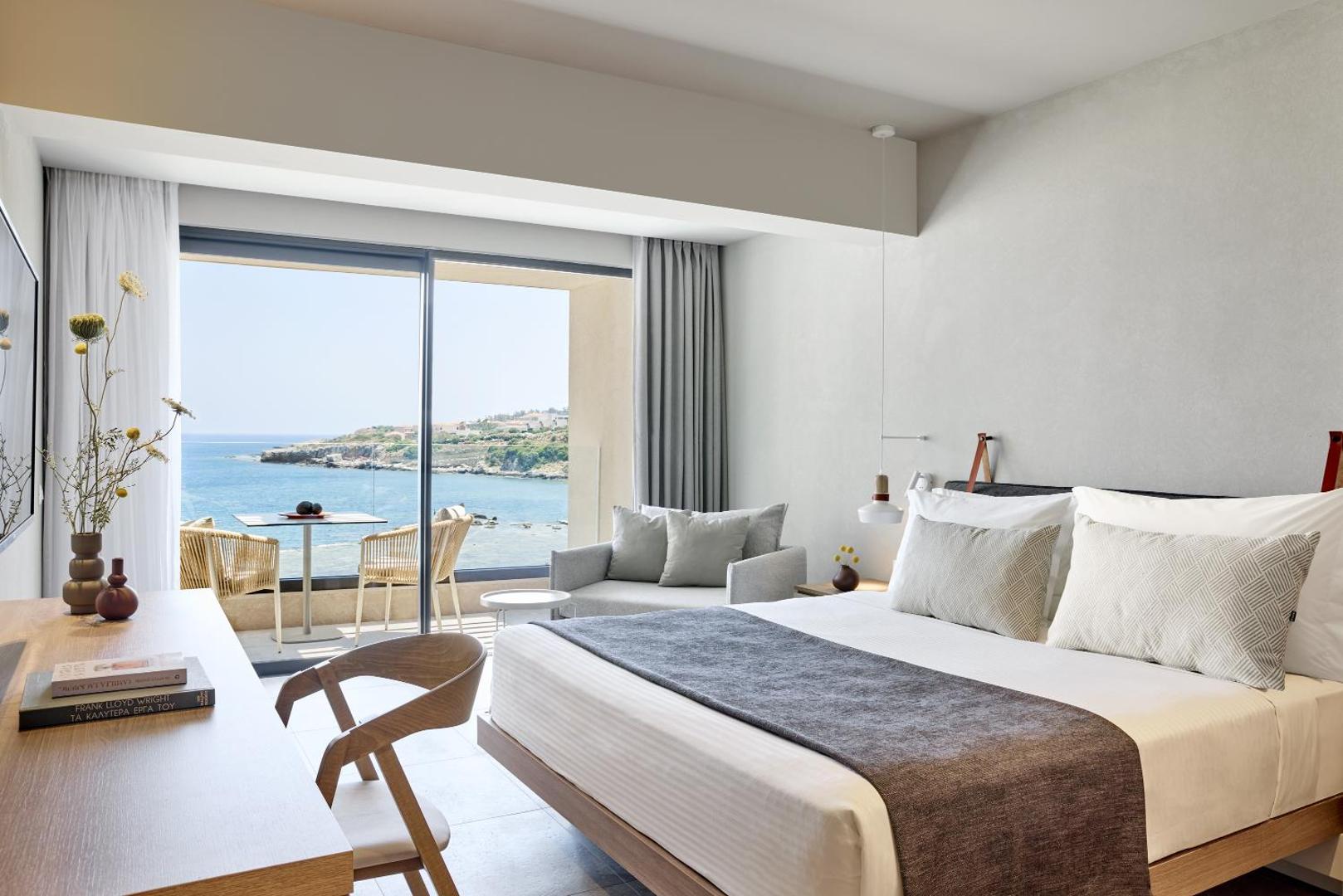 Elissa Lifestyle Resort gaišs numurs ar skatu uz jūru Rodā — moderna guļamistaba ar balkonu, kur atrodas galdiņš un krēsli