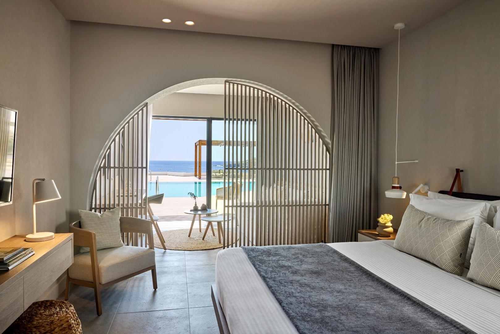 Elissa Lifestyle Resort luksusa numura interjers ar dekoratīvu koka starpsienu un skatu uz baseinu un jūru Rodā