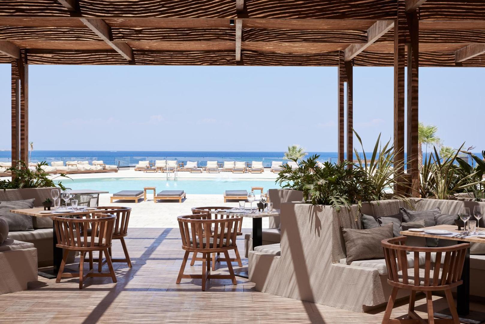 Elissa Lifestyle Resort āra restorāns pie baseina Rodā, plaša terase ar koka mēbelēm un skatu uz Vidusjūras horizontu