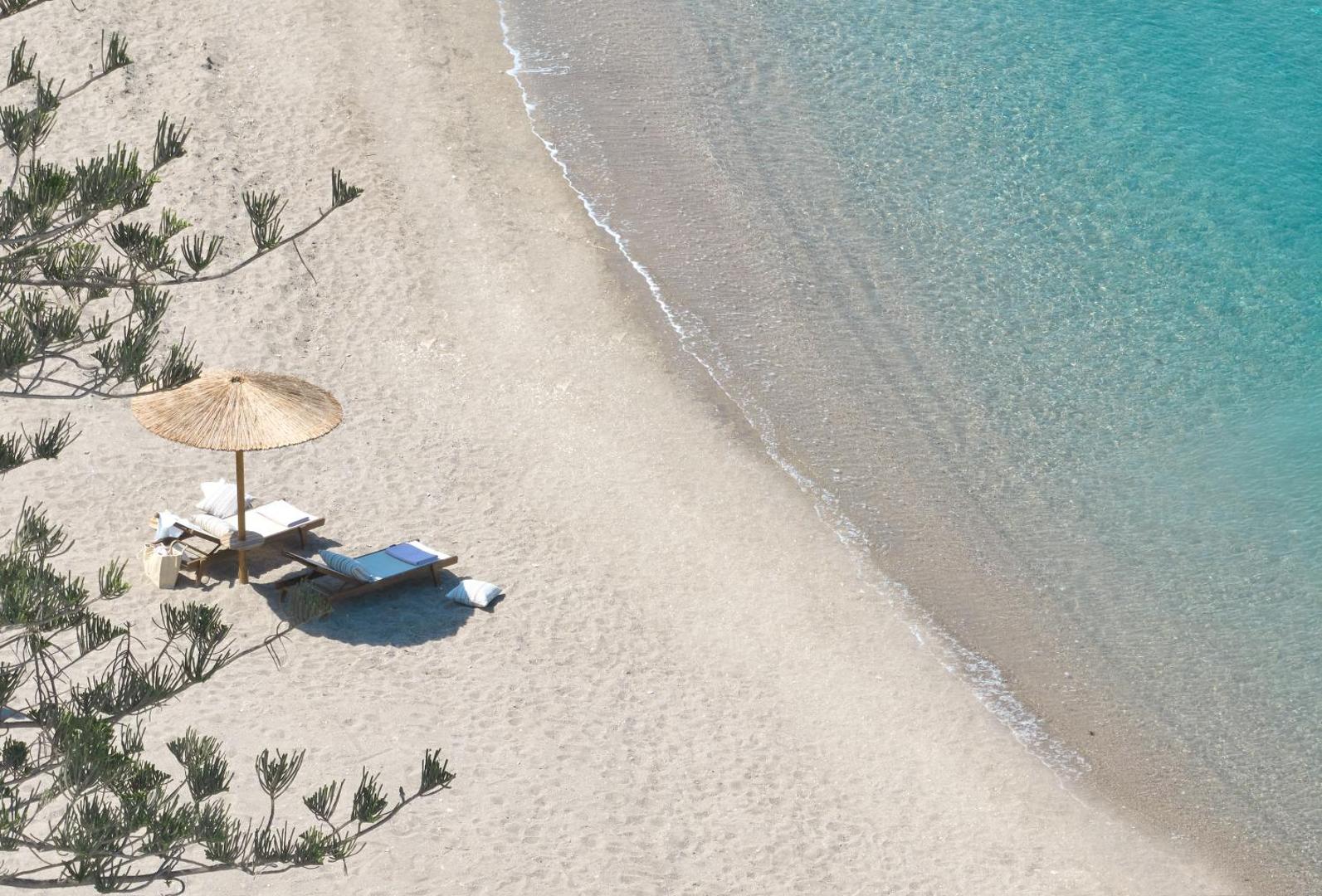 Skats no augšas uz Elissa Lifestyle Resort privāto pludmali Rodā, dzidrs tirkīza ūdens, smiltis un saulessargs ar zviļņiem