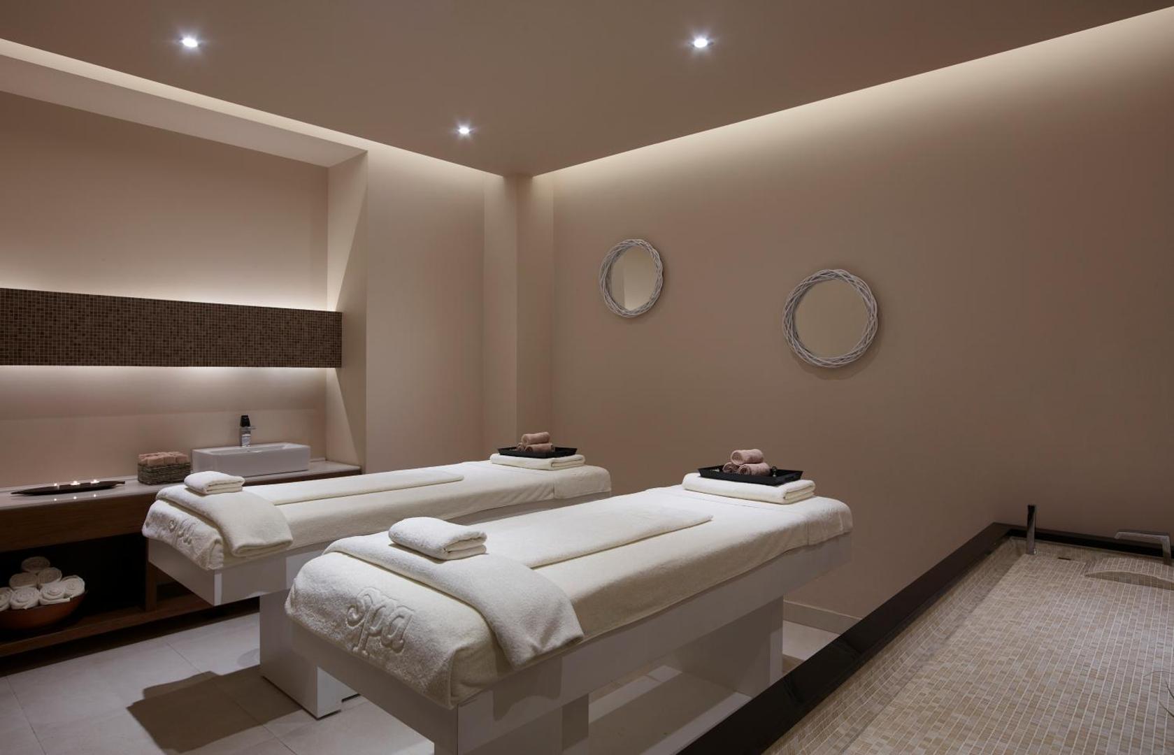 Mūsdienīgs spa procedūru numurs Boutique 5 Hotel & Spa viesnīcā Rodā ar divām masāžas gultām un mierīgu apgaismojumu