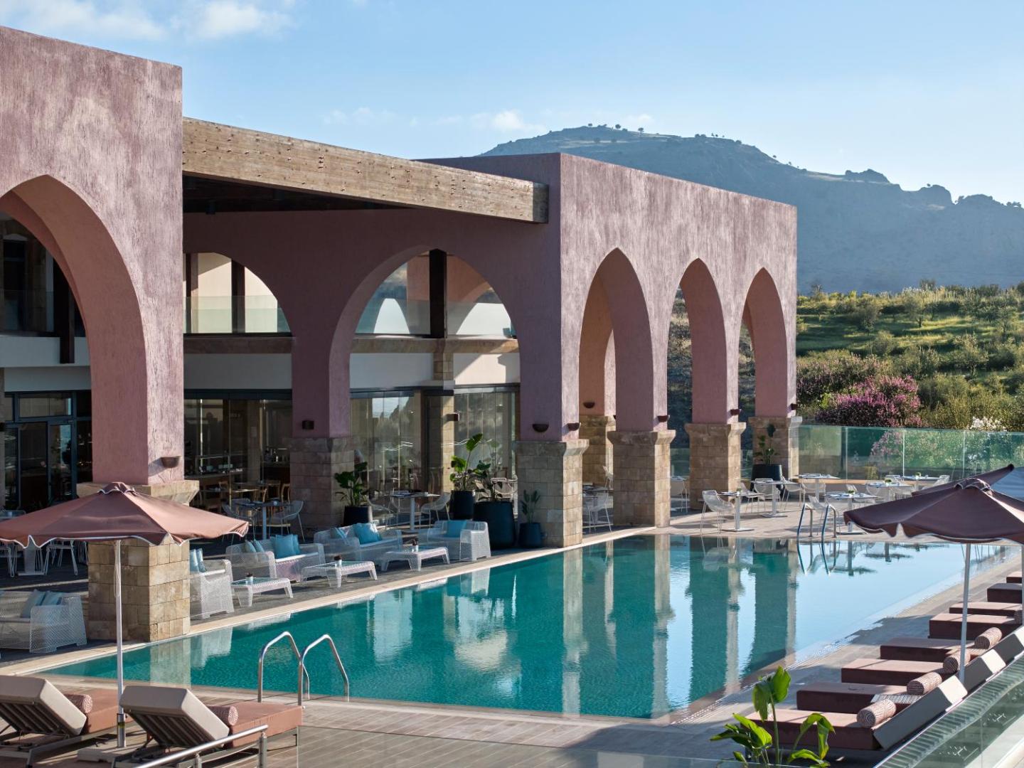 Boutique 5 Hotel & Spa arhitektūra ar arkām un āra baseinu Rodas salā — skats uz apkārtnes kalniem un dabu