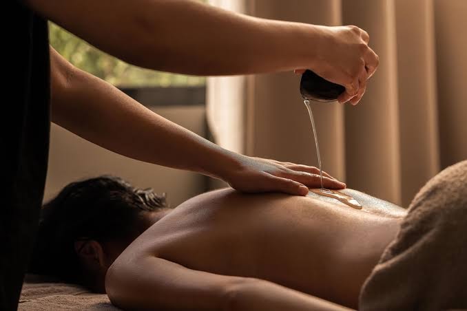 Relaksējoša eļļas masāža Casa Cook Rhodes spa centrā — profesionāla terapeita rokas un mierīga gaisotne atpūtai