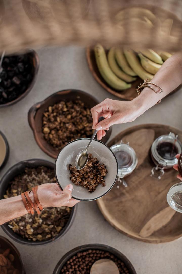 Veselīgas brokastis Casa Cook Rhodes restorānā — granola, svaigi augļi un medus dabīgā koka traukos
