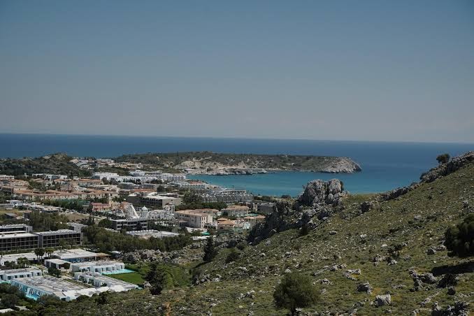 Panorāmas skats uz Casa Cook Rhodes viesnīcas kompleksu un Kolimbijas līci Rodas salā no blakus esošā kalna virsotnes