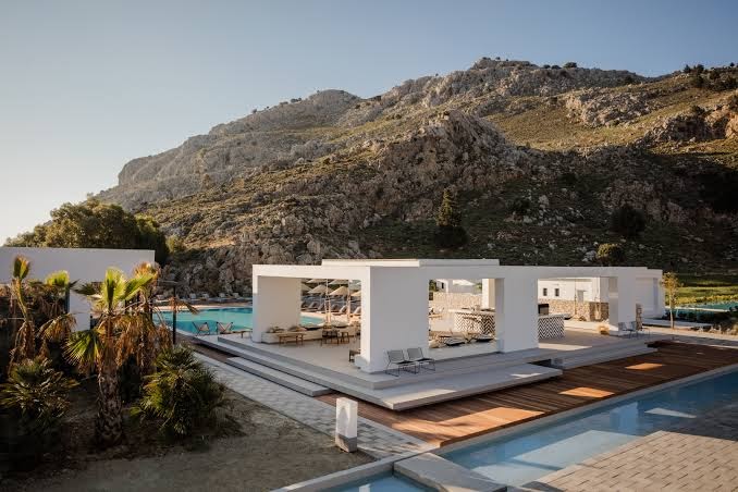 Casa Cook Rhodes koplietošanas atpūtas zona un baseins uz iespaidīga kalnu fona Rodas salā — plaša terase ar bāru