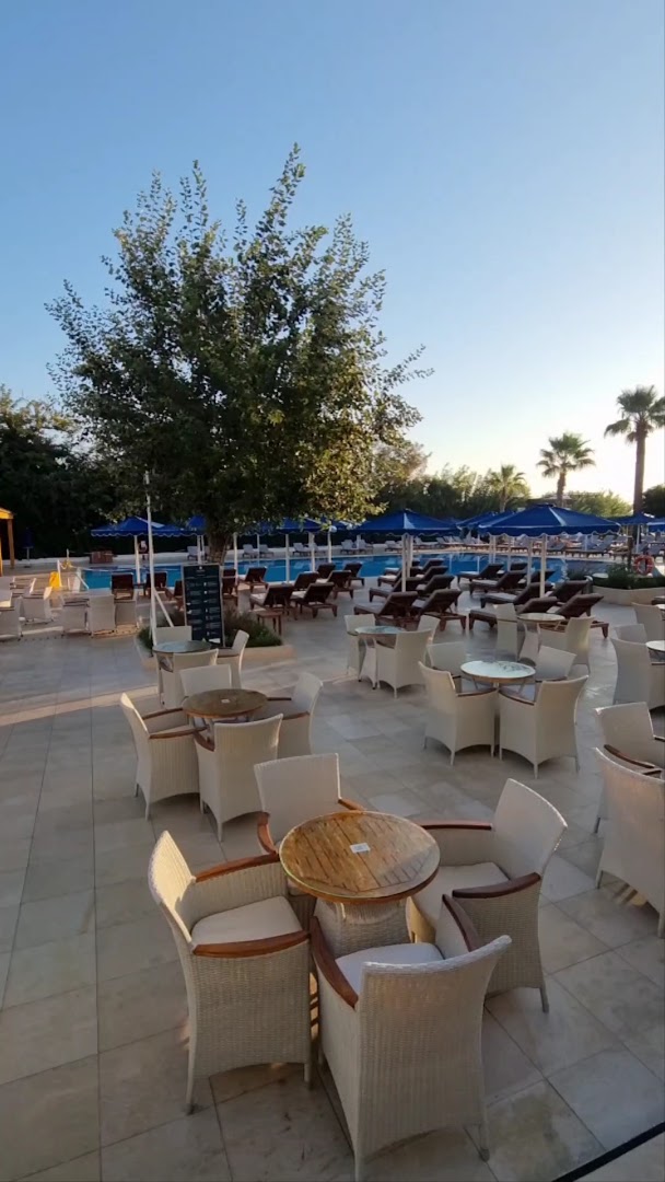 Mitsis Faliraki Beach Hotel & Spa āra terase ar galdiņiem pie baseina un saulessargiem Faliraki kūrortā, Rodā