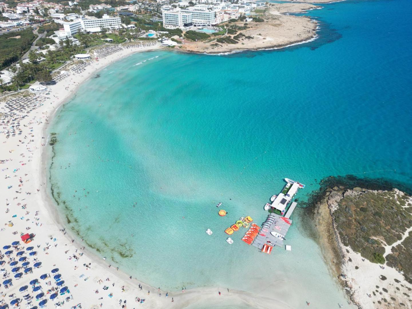 Aerofoto uzņēmums ar Aktea Beach Village piekrasti — ūdens sporta aktivitāšu centrs un tirkīza krāsas jūra Ajanapas līcī