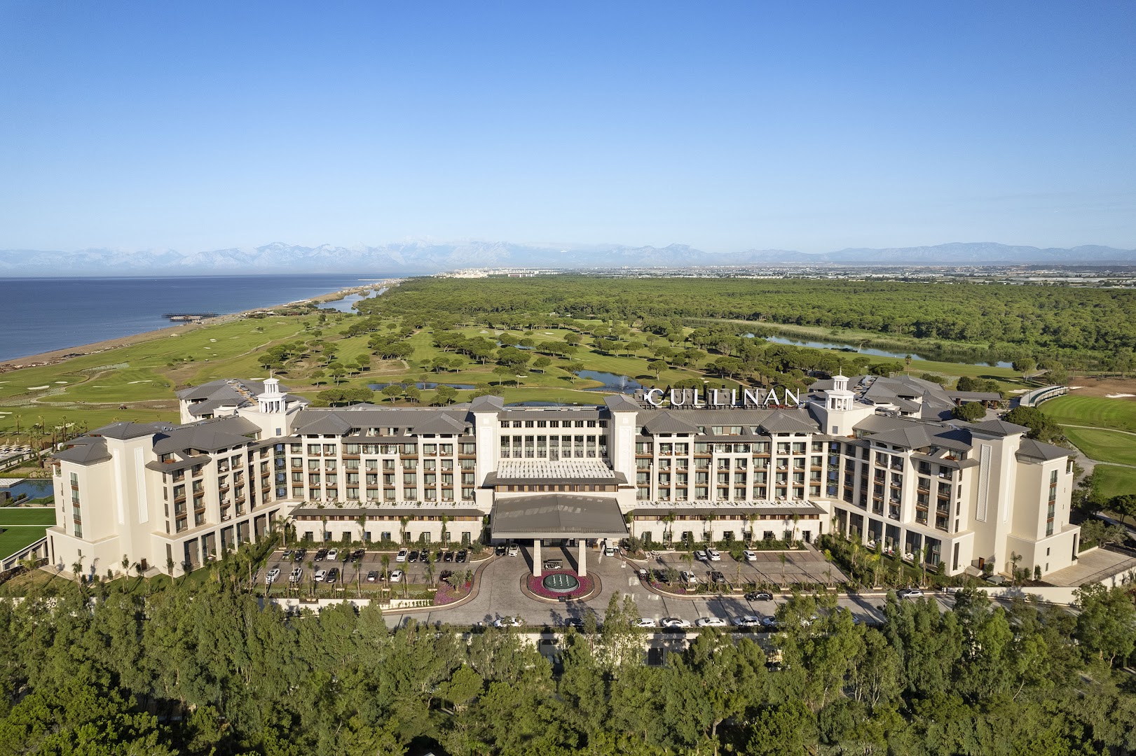 Cullinan Golf & Resort panorāmas skats no putna lidojuma uz viesnīcas galveno ēku, plašajiem golfa laukumiem un piekrasti Belekā.