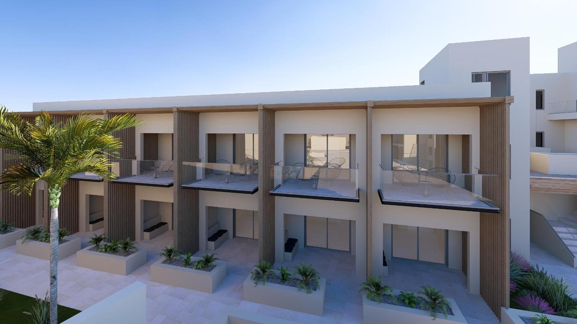 Alianthos Estate Resort divstāvu numuru korpuss ar balkoniem un terasēm — gaiša fasāde un palmas piekrastē
