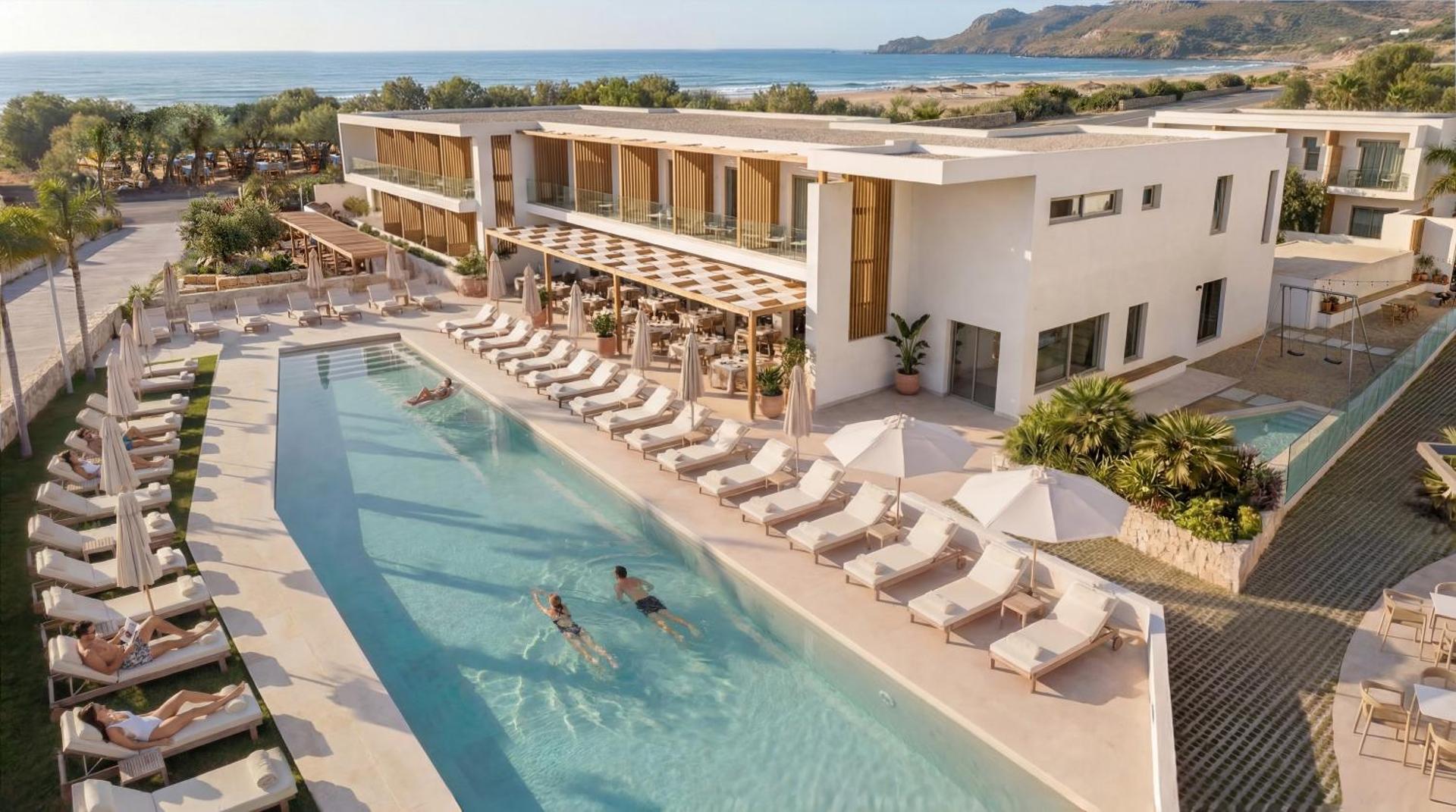 Alianthos Garden Hotel aerofoto ar garu peldbaseinu, sauļošanās krēsliem un viesnīcas ēku pie jūras Plakijas kūrortā, Krētā