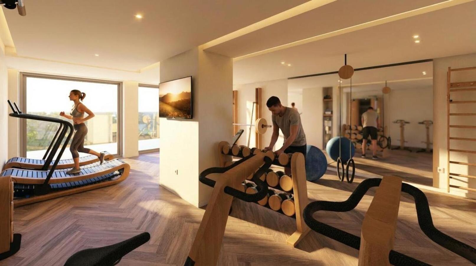 Alianthos Garden Hotel moderni aprīkota fitnesa zāle ar skrejceliņiem un brīvajiem svariem, koka apdare un plaši logi