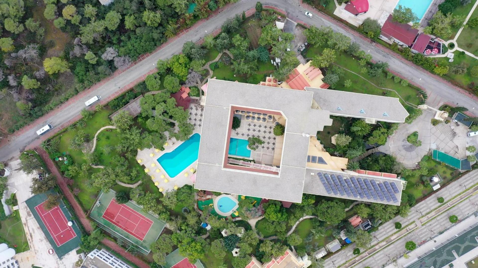 Aerofoto uzņēmums ar Asteria Collection Side viesnīcas jumtu, saules paneļiem, baseinu un sporta laukumiem zaļā teritorijā
