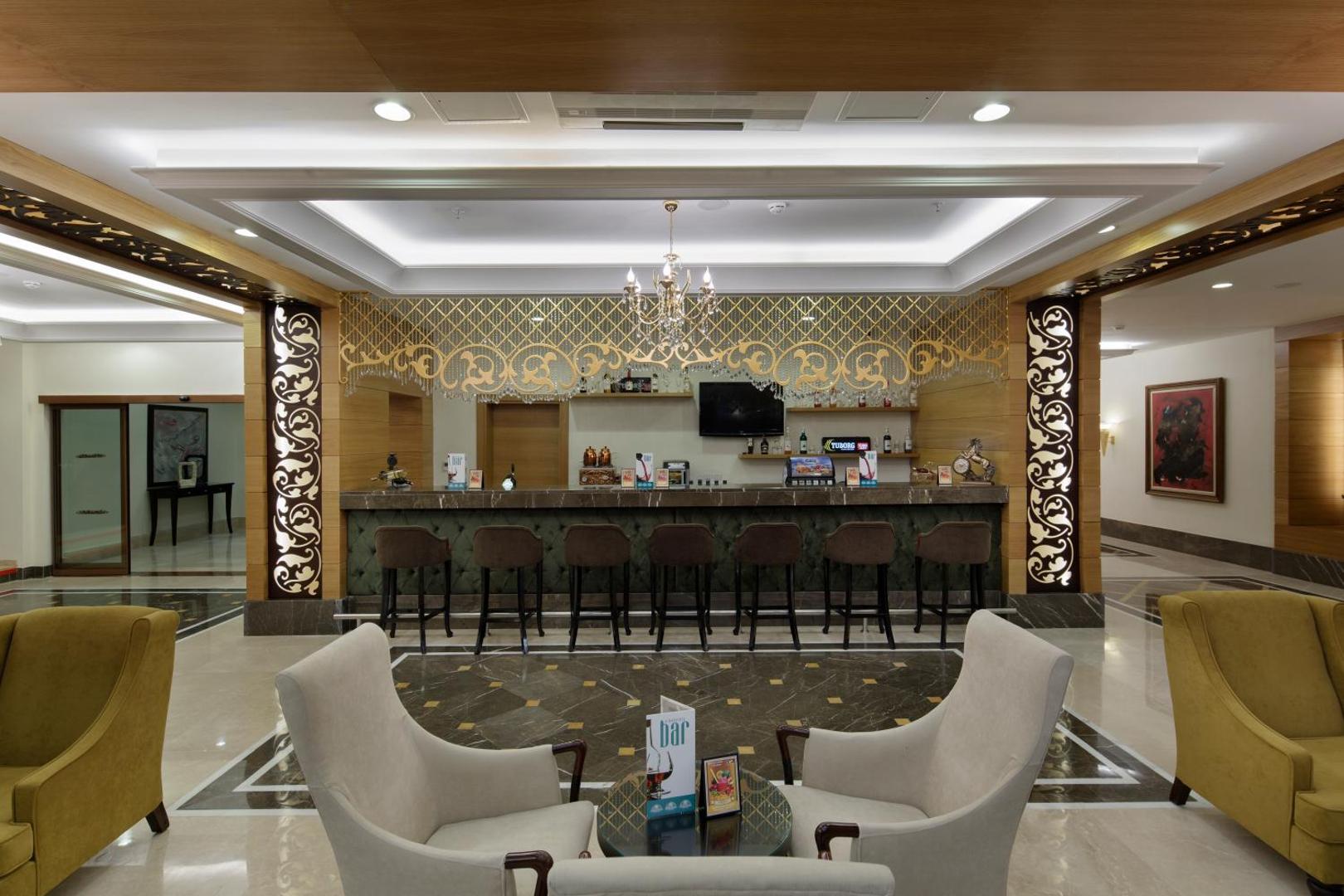Alba Resort Hotel lobby bārs ar elegantu interjeru, mīkstiem atpūtas krēsliem un greznu apgaismojumu viesu uzņemšanai