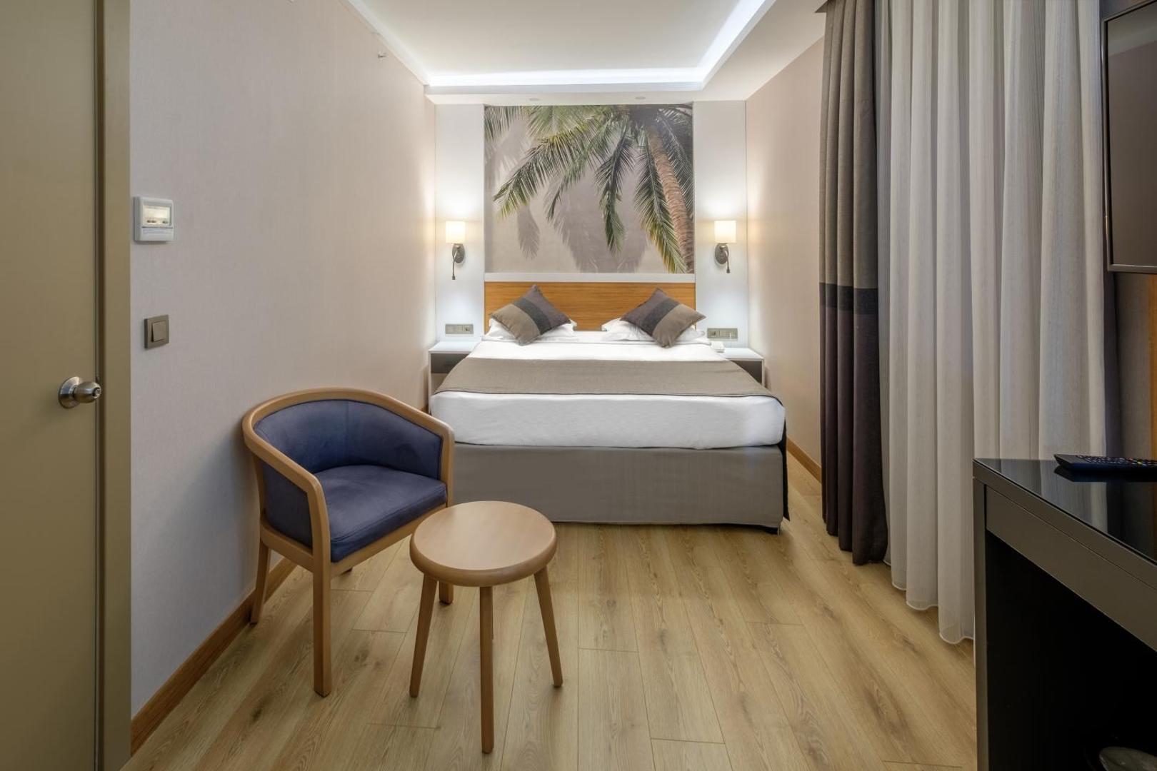 Alba Resort Hotel mājīgs numurs ar divguļamo gultu, atpūtas krēslu un gaišu interjeru Sides piekrastē