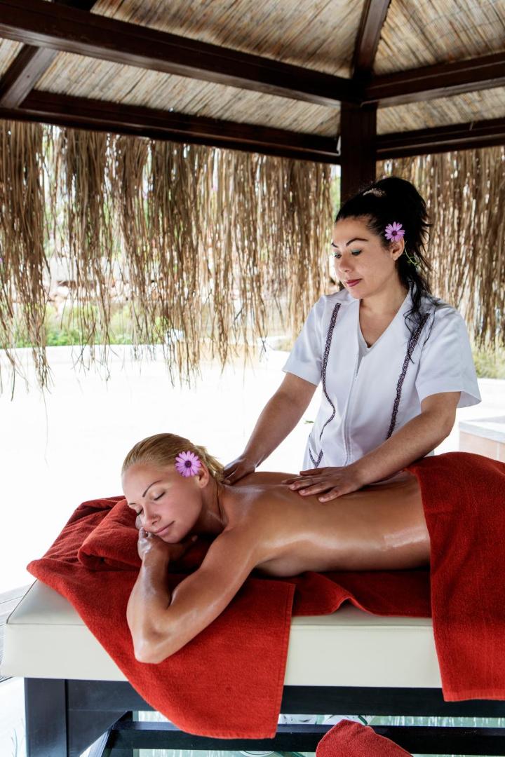 Relaksējoša muguras masāža Alba Resort Hotel spa zonā brīvā dabā zem nojumes ar skatu uz dārzu