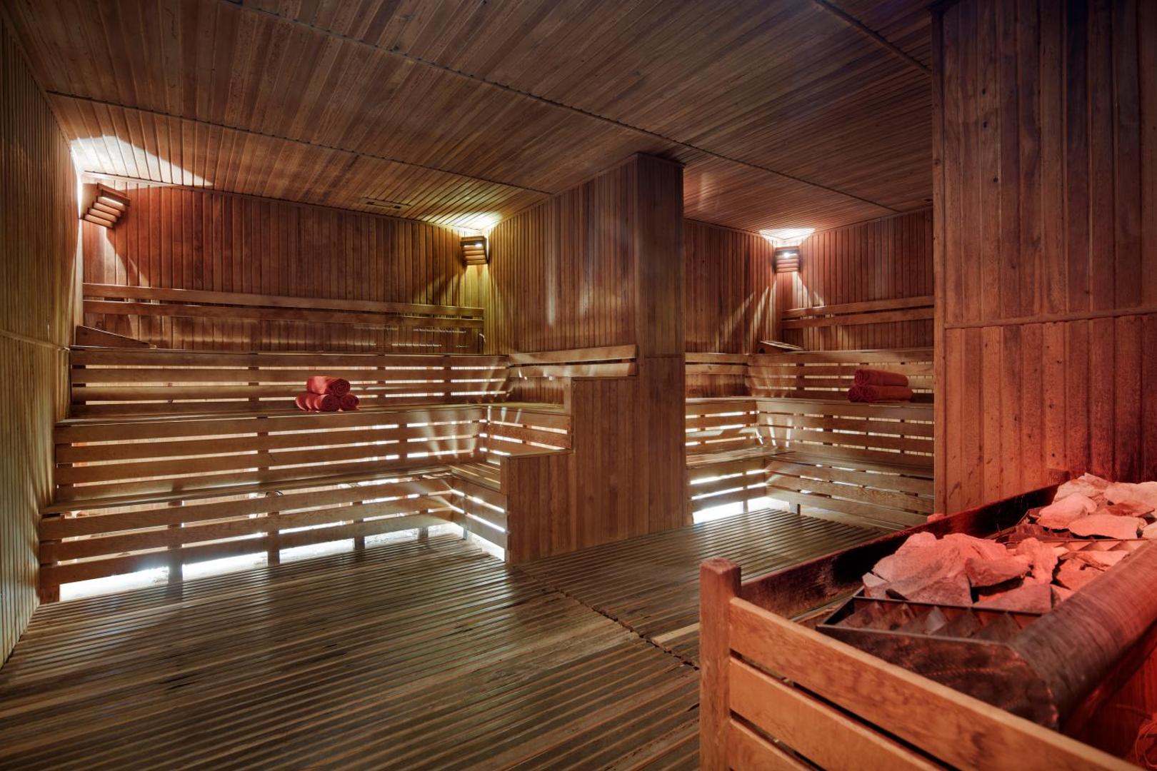 Alba Resort Hotel spa centra plašā koka sauna ar vairākiem līmeņiem un akmeņu krāsni relaksācijai