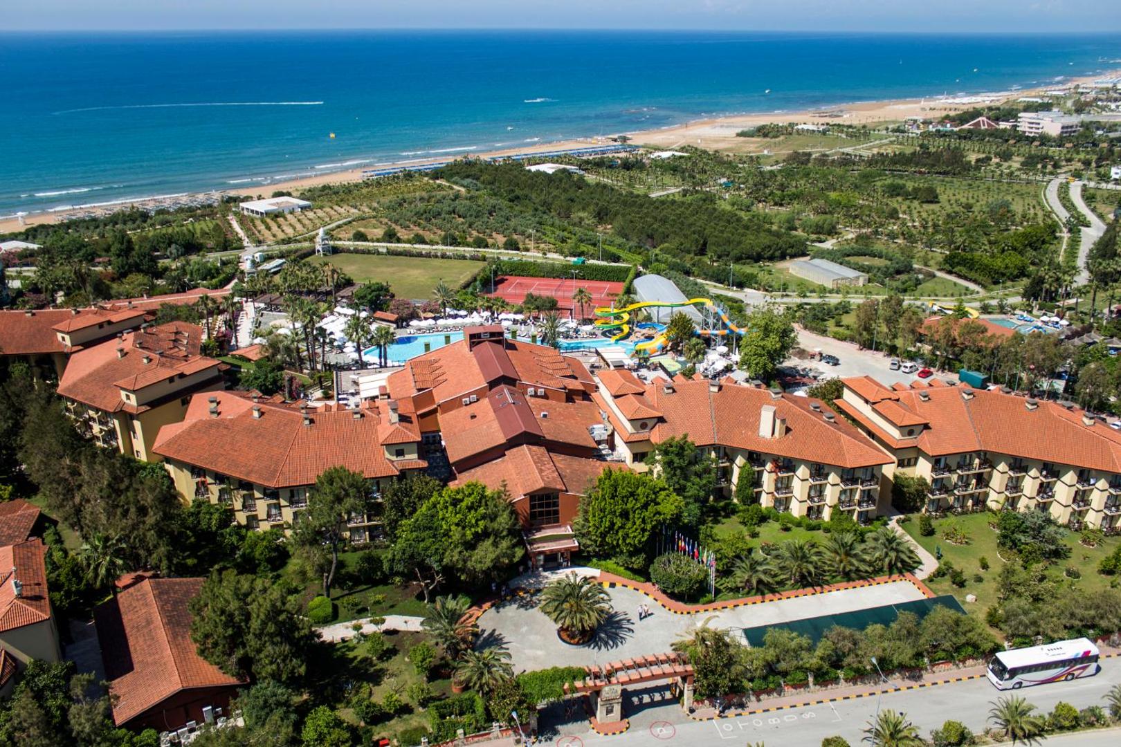 Alba Resort Hotel skats no augšas uz galveno ēku kompleksu, dārzu un zilo jūras horizontu tālumā Sides piekrastē