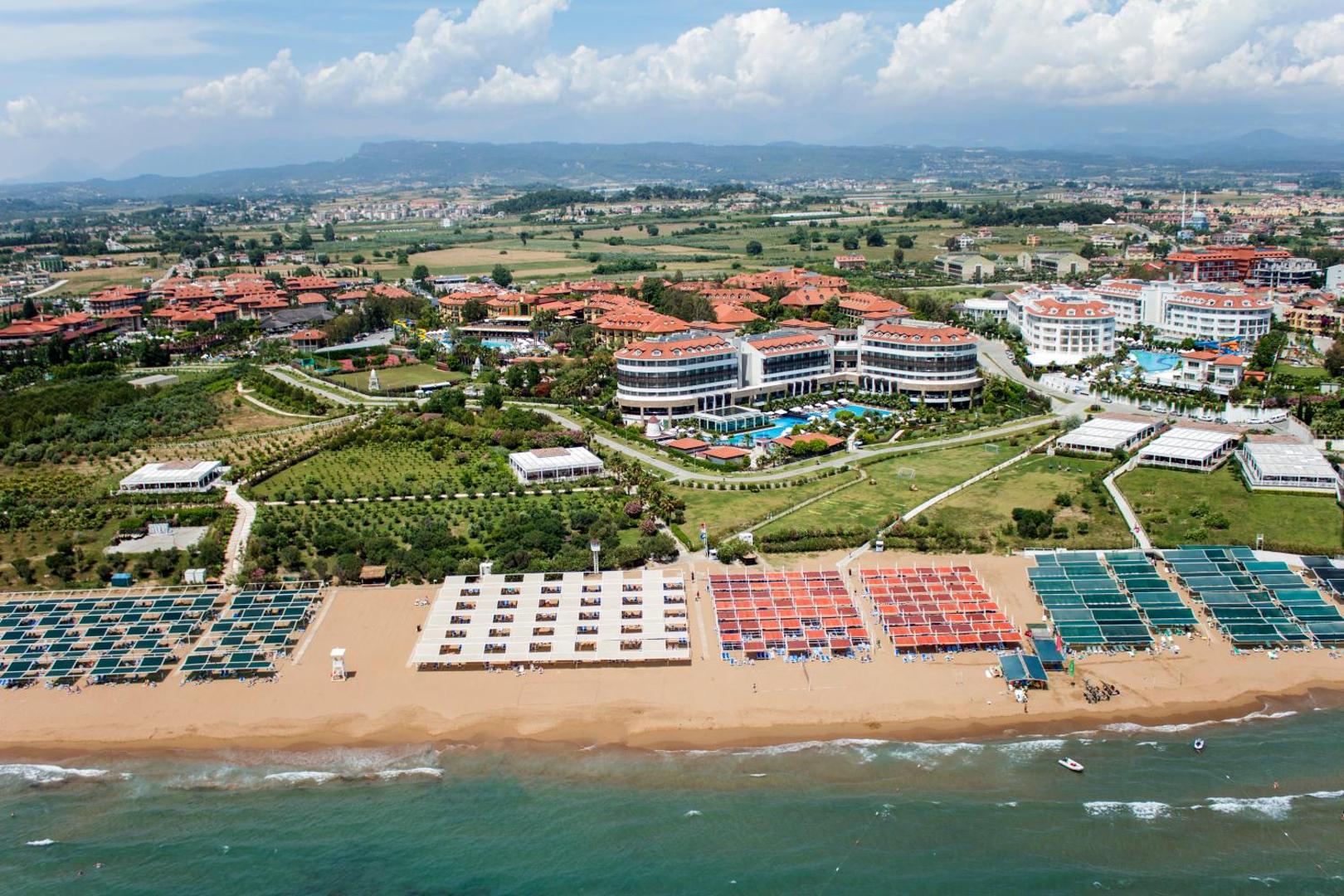 Alba Resort Hotel panorāmas skats no putna lidojuma uz viesnīcas kompleksu, baseiniem un plašo smilšu pludmali Sidē