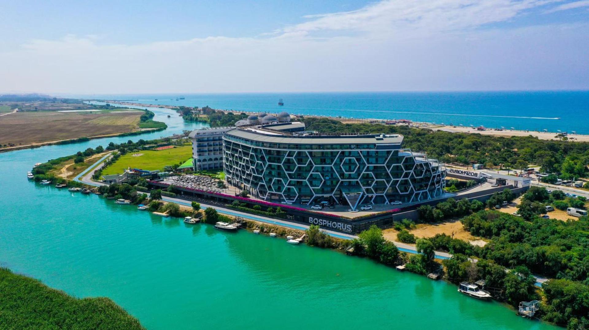 Bosphorus Sorgun Hotel ēka un apkārtne no putna lidojuma pie upes ietekas jūrā Titrejengolas reģionā, Turcijā — moderna arhitektūra un zila ūdens ainava