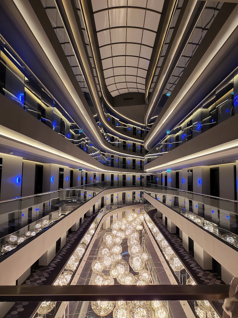 Bosphorus Sorgun Hotel modernais ātrijs ar daudzlīmeņu gaiteņiem un iespaidīgām bumbveida lustrām — viesnīcas iekšējā arhitektūra un apgaismojums