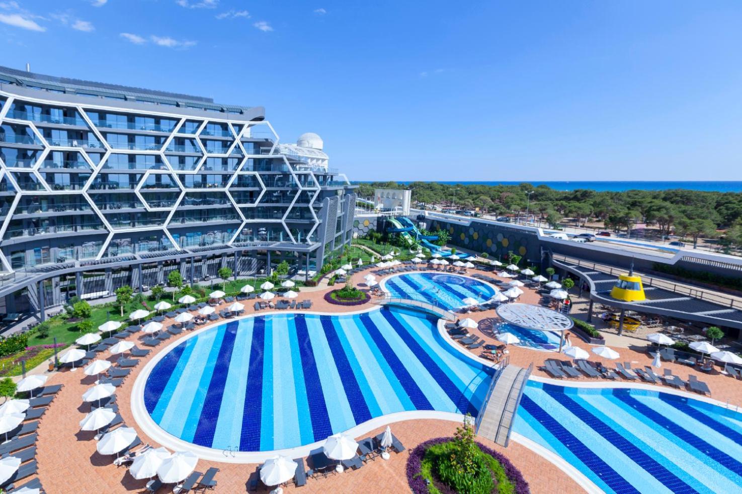 Bosphorus Sorgun Hotel plašais baseinu komplekss no augšas — redzami vairāki baseini, saulessargi un skats uz jūru tālumā