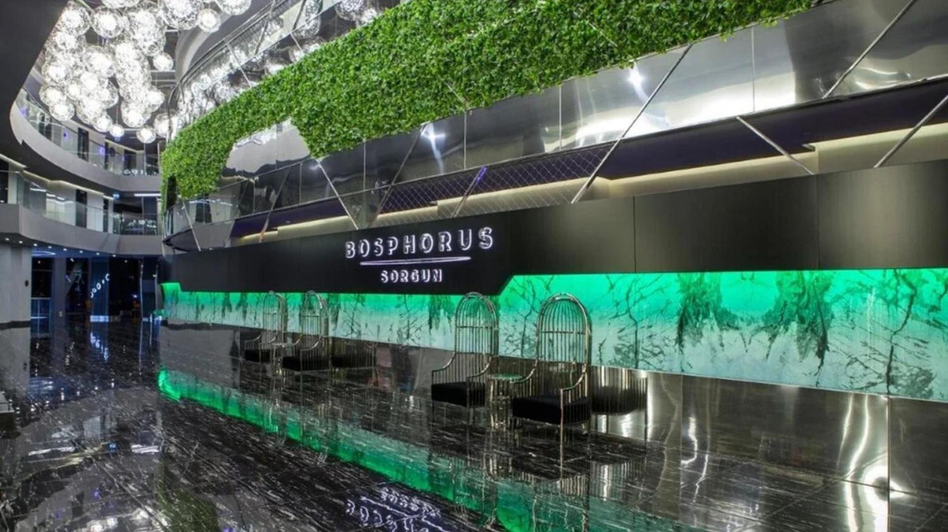 Bosphorus Sorgun Hotel vestibils ar recepcijas zonu, zaļajiem augiem un moderniem dizaina krēsliem — luksusa interjers un marmora grīdas
