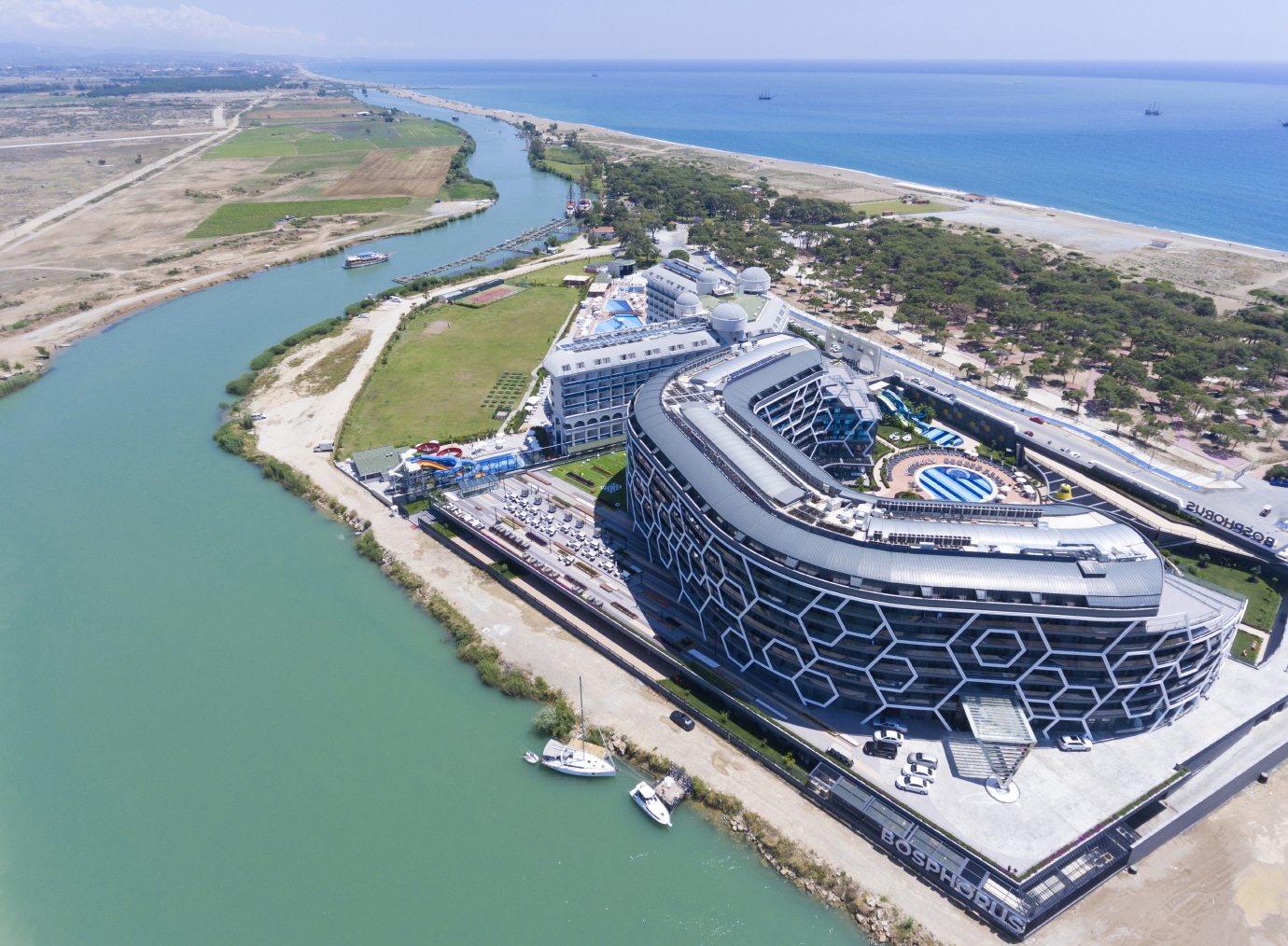 Bosphorus Sorgun Hotel teritorijas panorāmas skats no augšas, parādot viesnīcas novietojumu blakus upei un netālu esošo pludmali