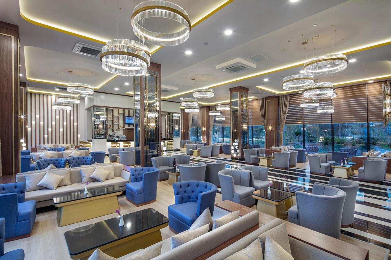 Aydinbey Queen's Palace & SPA plašais lobby bārs ar modernām mēbelēm, kristāla lustrām un lieliem logiem Belekā, Turcijā