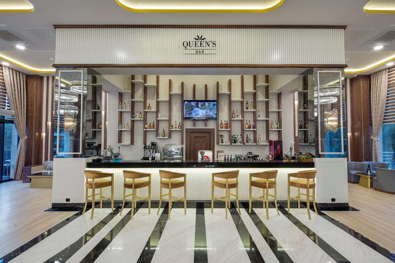 Aydinbey Queen's Palace & SPA viesnīcas Queen's Bar bāra lete ar moderniem bāra krēsliem un plašu dzērienu izvēli Belekas reģionā.